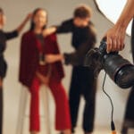 Hands, photographer and people in backstage, camera and pictures for fashion magazine and studio. P.