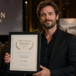 European photographer holding an award certificate at a ceremony